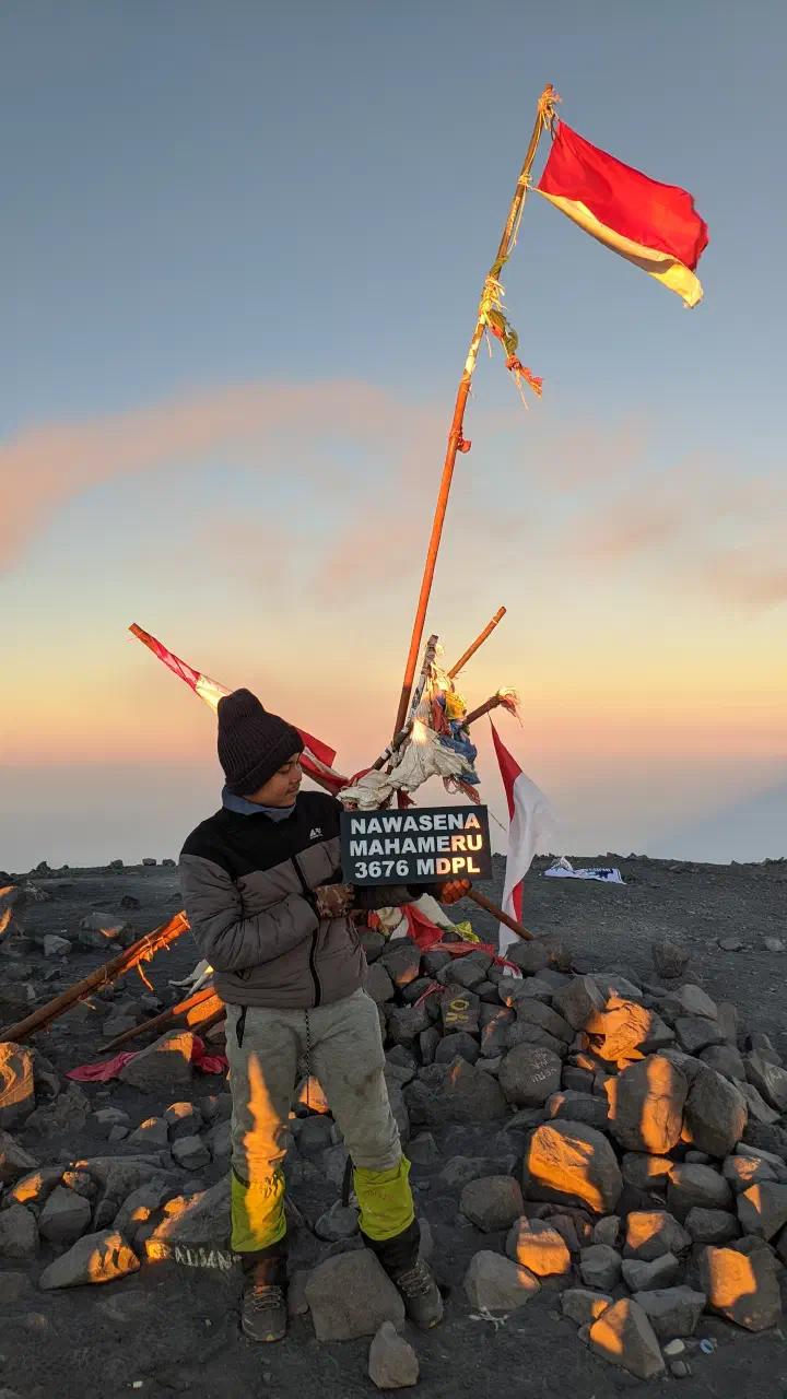 Saya berfoto dengan membawa papan nama bertuliskan &ldquo;NAWASENA MAHAMERU 3676 MDPL&rdquo; dengan latar belakang bendera Merah Putih yang berada di Puncak Mahameru pencapaian terbesar saya saat ini